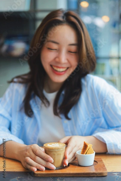 Obraz Close up Asian woman hands holding a cup of hot coffee at modern cafe, representing freelance lifestyle, digital nomad, and online business success