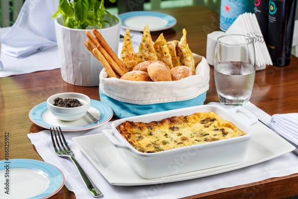 Obraz Fresh lasagna in a baking dish with bread basket.