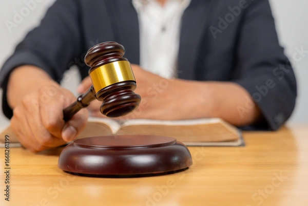 Fototapeta Close-up of a gavel with a judge in the background, symbolizing law, legal proceedings, justice, and courtroom authority