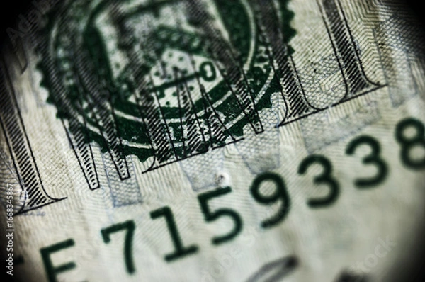 Fototapeta Detailed close-up reveals United States hundred dollar bill with serial numbers, highlighting Benjamin Franklin's portrait and intricate security features. Blurred background