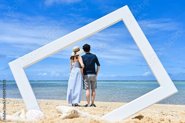 Obraz 沖縄のビーチでフォトフレームの中にいるかのように撮影したカップルのイメージ写真