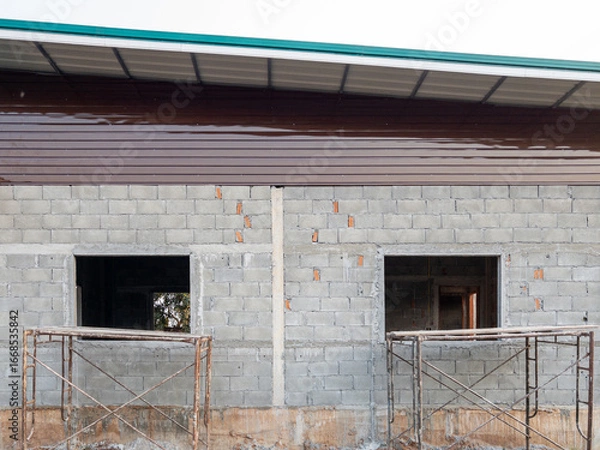 Fototapeta Small Rural House Under Construction with Scaffolding.