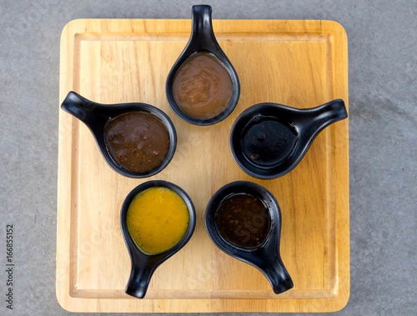 Obraz Many sauce in black spoon