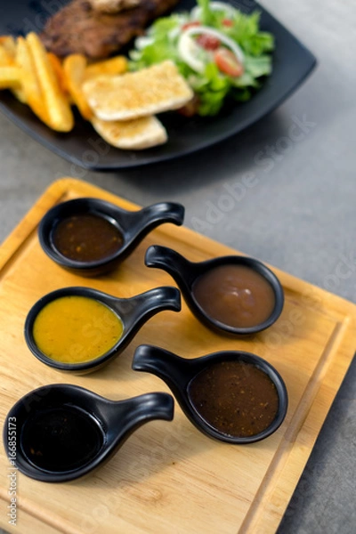 Obraz Many sauce in black spoon