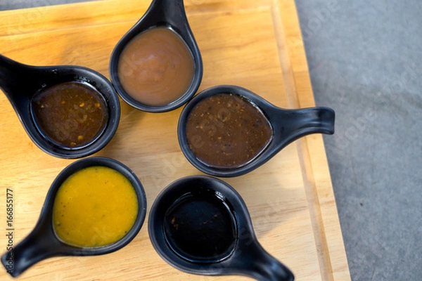 Obraz Many sauce in black spoon