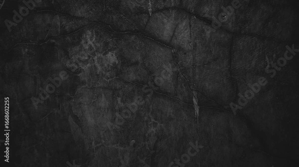 Fototapeta Textured black wall with cracks and dark shading, great for backgrounds in design projects needing a distressed look. 