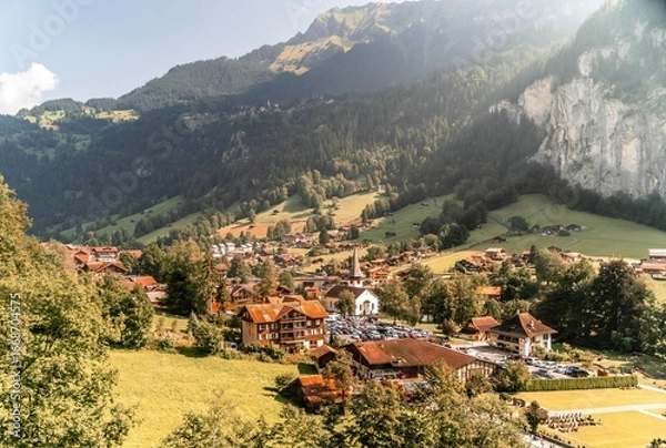 Fototapeta The charming Swiss village of Lauterbrunnen in the Alps basks in sunshine.