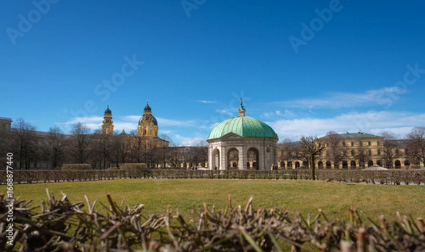 Obraz The Diana Temple (Dianatempel) in the Hofgarten, Munich, Germany, with the baroque towers of the Theatine Church in the background. A scenic blend of garden, culture, and historic architecture.