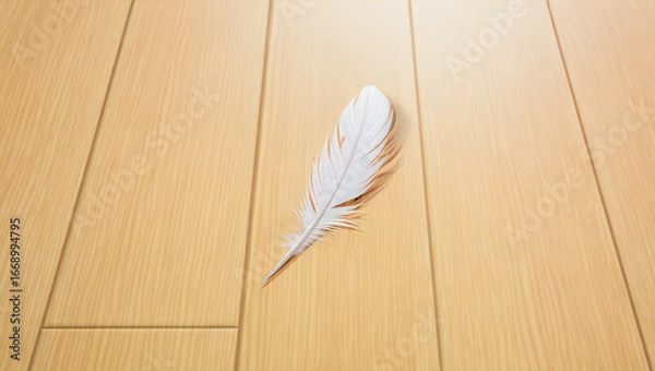 Fototapeta White feather lying on a wooden surface with a soft and gentle appearance