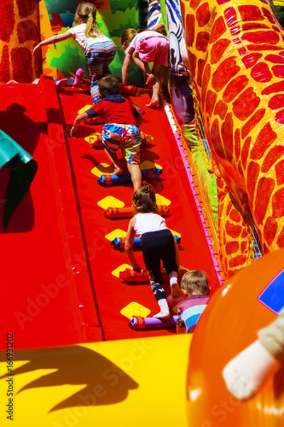 Obraz Children play on the inflatable children's playground in the city park. May 28, 2017.