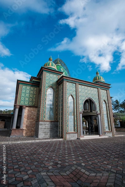 Fototapeta Ornate Mosque with Green and Gold Geometric Patterns and Majestic Domes under Blue Sky