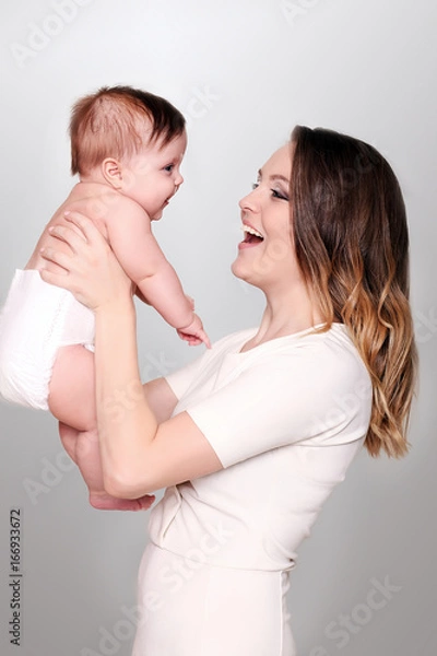 Fototapeta A happy family. Mother holding little daughter in her arms.
