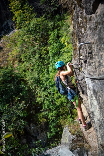 Fototapeta Via Ferrata - Jeune femme pratiquant escalade sur une Via ferrata dans les Alpes Française