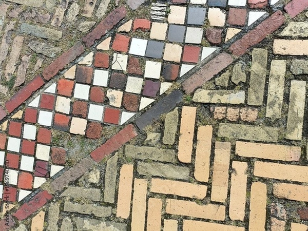 Fototapeta Decorative square and rectangular paving bricks in contrasting colors and lines on a European walkway