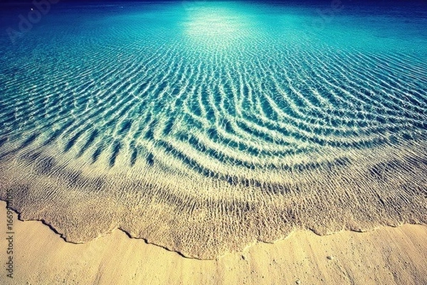 Fototapeta Tranquil, shallow turquoise water lapping at a sandy beach