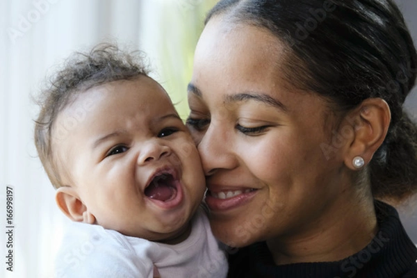 Fototapeta Close up portrait of a African American woman holding a baby girl