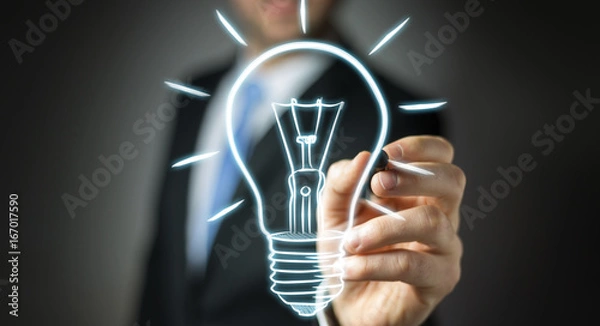 Fototapeta Businessman drawing a sketch lightbulb with a pen