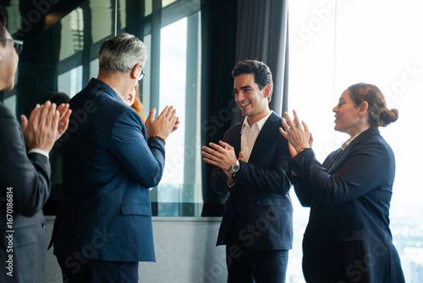 Fototapeta Boss and group of professional colleagues enthusiastically applaud and welcome a new employee in a modern office, celebrating the start of a new job and team integration with positivity and support.