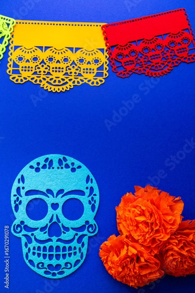 Fototapeta Day of the Dead decorations with colorful papel picado, cut-out skulls, and marigold flowers