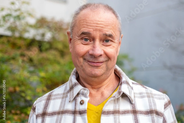Fototapeta happy positive caucasian mature man 60-65 years old smiling on green natural background, good mood, age-related changes, mental human health