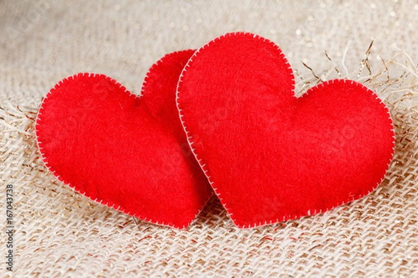 Fototapeta Two hearts symbol of love on burlap background.