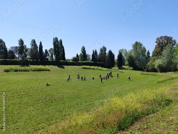 Fototapeta Ostia, Rome, April 15, 2025, children from an elementary school, on a school trip, have fun running and playing in a protected ecological oasis.