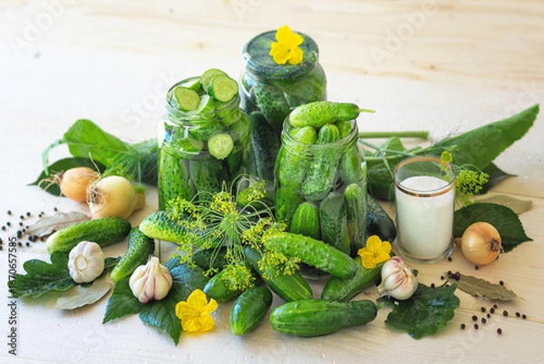 Fototapeta Salted homemade cucumbers in jars on a wooden natural background. Pickled cucumbers with dill, garlic, onion and spices. Canned cucumbers. Cucumbers with dill. Recipe for home canning. Canning and pre