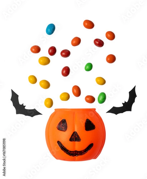 Fototapeta Jack o lantern pumpkin bucket with colorful candies flying out and paper bats isolated on transparent background. 