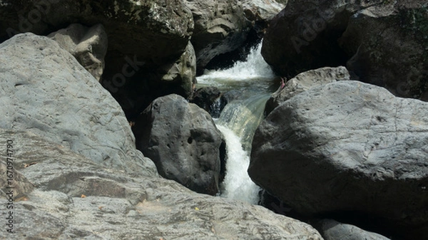 Fototapeta Cascading Water Over Rocks in a Serene Stream