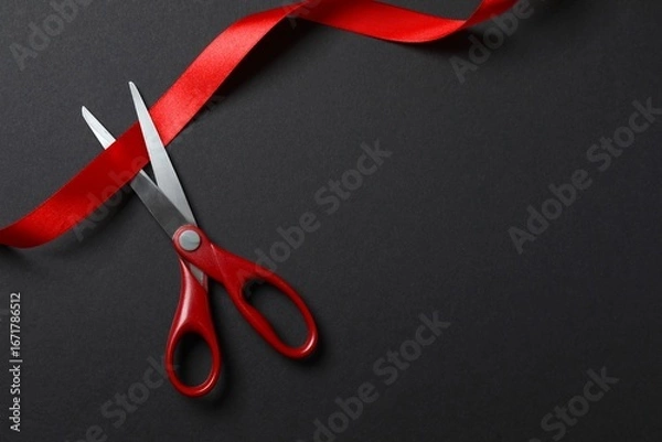 Obraz Beautiful red ribbon and scissors on black background, flat lay with space for text. Ceremonial tape cutting