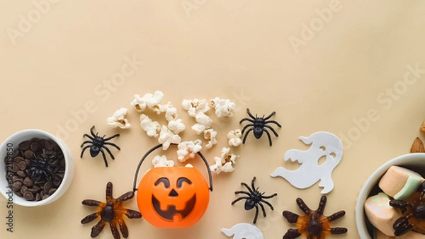 Fototapeta candy, popcorn, chocolate in a bowl and a Halloween themed background with space for text