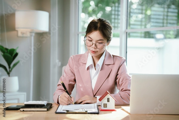Obraz A woman hands over house keys with documents, symbolizing real estate contracts, property purchase, mortgage, investment, ownership, successful housing deals, and financial planning.