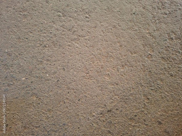 Fototapeta Detailed close-up of a rough brown textured surface, resembling asphalt, concrete, or compacted ground. This high-resolution image works well for backgrounds, construction themes, industrial design