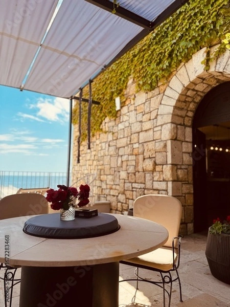 Fototapeta Cozy café terrace with a beautiful sea view, offering a relaxing and scenic atmosphere.