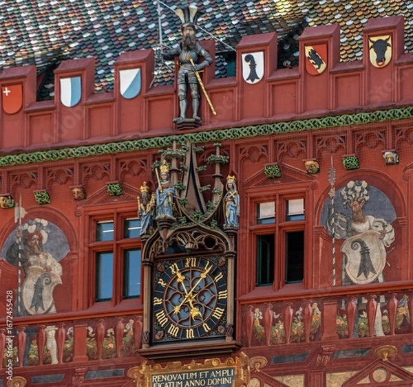Fototapeta The facade of the 'red house' - the town hall in Basel, with a clock, a statue of a knight with the city's coat of arms and interesting paintings