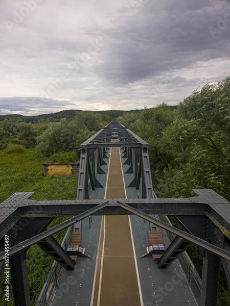 Fototapeta Vertical photo of the old railway bridge in Siekierki between Poland and Germany, a part of a popular bicycle route.