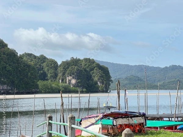 Fototapeta A river with a green forest on either side, big mountain side of river in Krabi Thailand.
