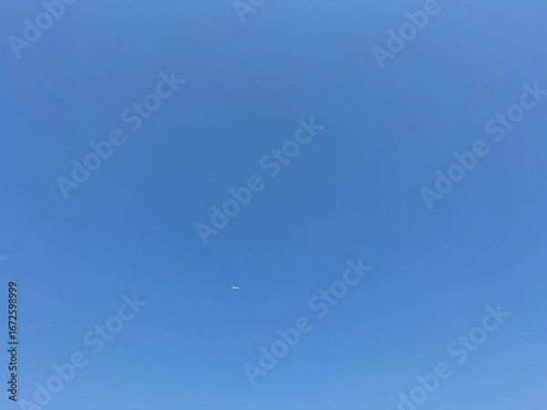 Fototapeta airplane in the blue sky, blue sky with could. Jet airplane flying overhead in clear blue sky diagonally with condensation trail, Aircraft in the air.
