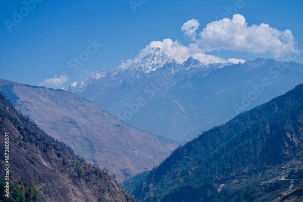 Fototapeta Himalayan mountain landscape in the alps with clouds and blue sky background