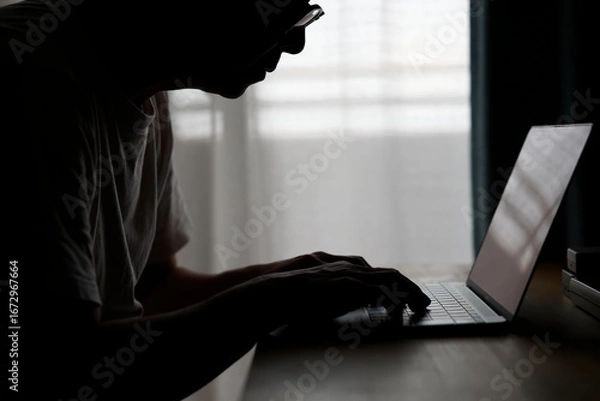 Fototapeta 暗い部屋でパソコンを使う男性