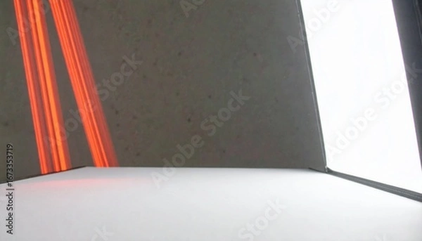 Fototapeta A curved red laser beam arcs elegantly from the bottom left to the top right, creating a slight reflection and glow. The beam is centered in the frame, with a black-to-transparent gradient background 