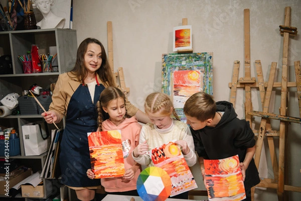 Fototapeta Happy children showing their landscape drawings in art class. Children painted pictures in a workshop in art class. Art lesson. Education and learning concept.