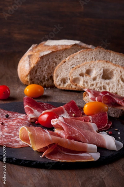 Fototapeta Meat appetizers - sausage, ham, bacon with fresh bread and tomatoes