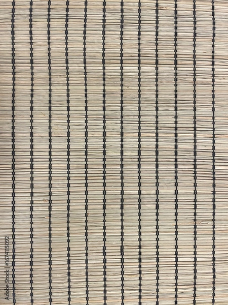 Obraz Close-up of bamboo mat texture with vertical black threads. Natural woven surface in beige tones, rustic eco-friendly design for home decor, flooring, crafts, background