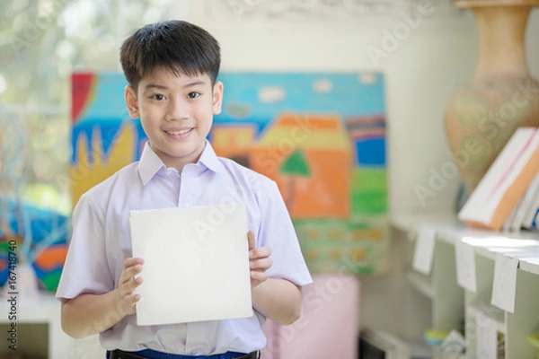 Obraz Happy asian boy hand holding blank paper board and looking at camera
