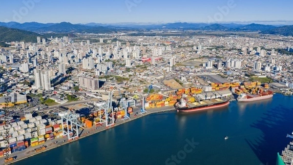 Obraz Aerial panoramic view of the Port of Itajaí with container ships and city skyline in the background.