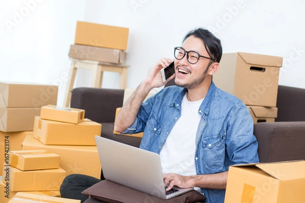 Fototapeta Young Asian Man using Smartphone for work at home, Young Owner Man receive Order form Customer , SME, Delivery, Man with Online Business or SME Concept.