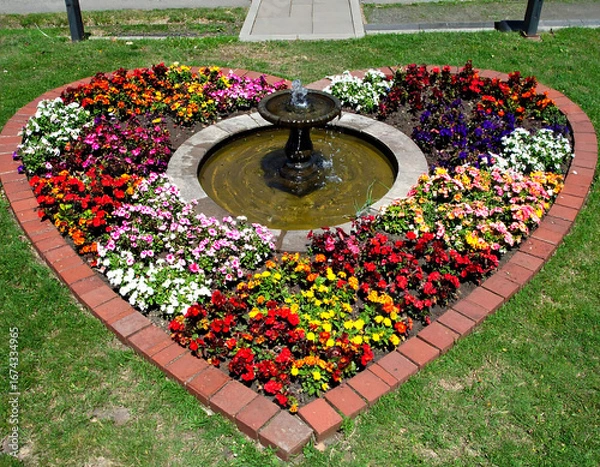 Fototapeta Heart shaped flower bed with fountain