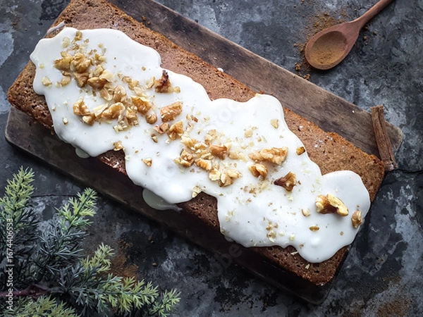 Fototapeta cinnamon cake with walnuts on a wooden board with a rustic background