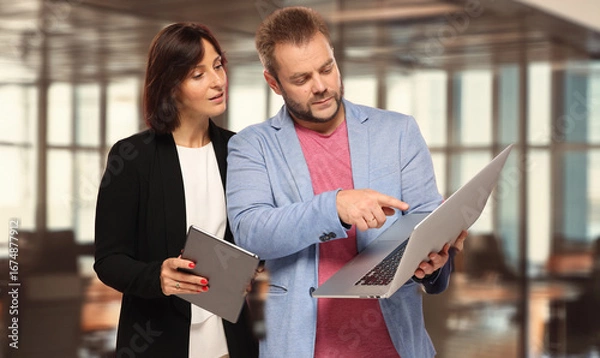 Fototapeta colleagues solve a problem plan discuss two professional people work together use electronic devices